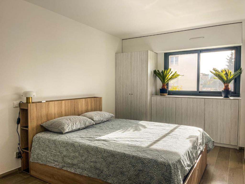 a bedroom with a bed and a window at L’Escale Borely in Marseille
