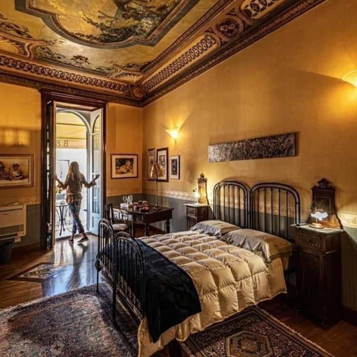 a woman walking into a bedroom with a bed at Palazzo Melluso LUXURY SUITE in Porto Empedocle