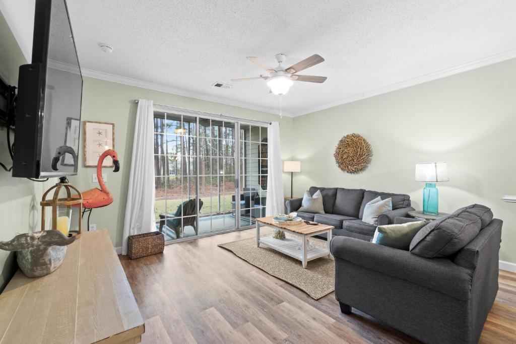 a living room with a couch and a tv at Barefoot Resort - Arbor Trace 613 - Windy Hill in North Myrtle Beach