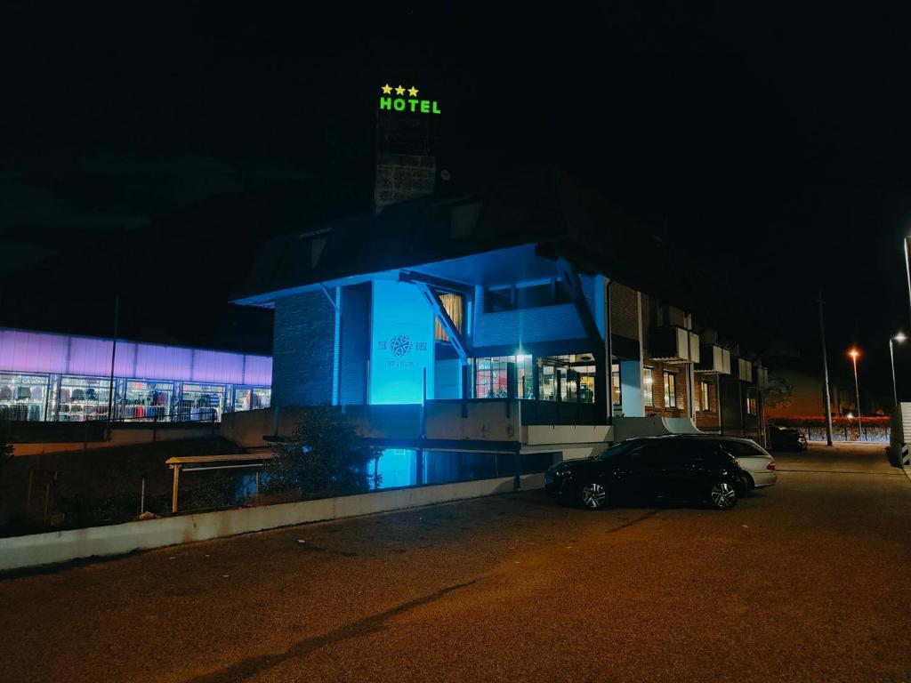un edificio azul con un coche aparcado en un estacionamiento en Hotel la Rosa, en Tolmezzo