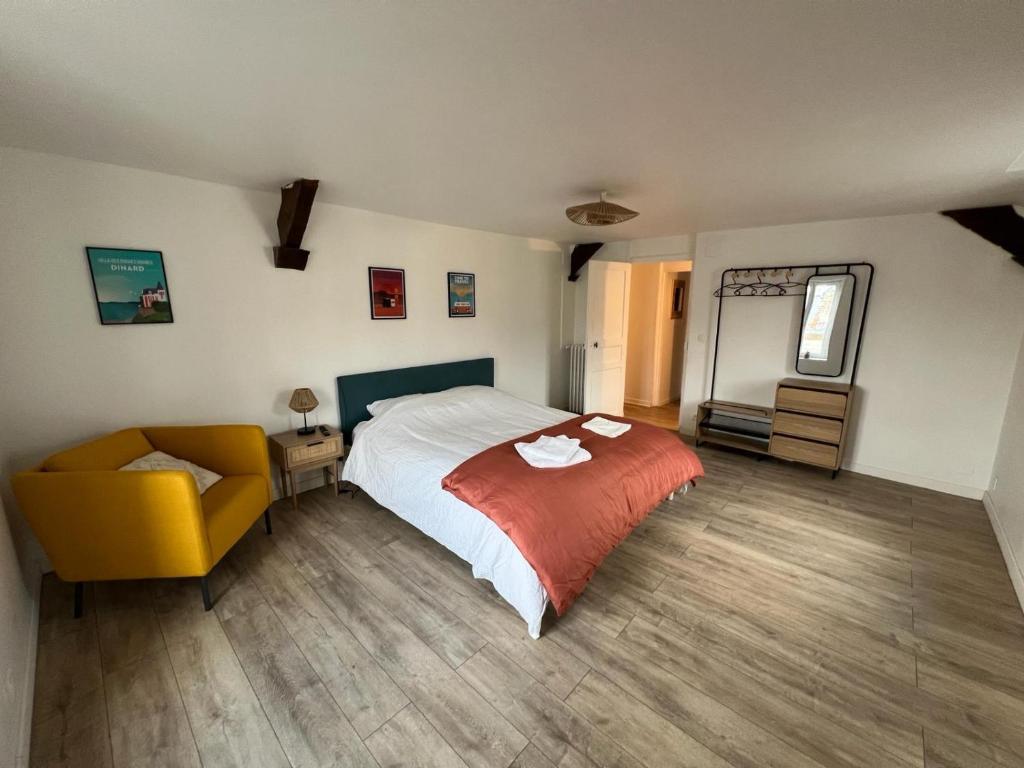 una camera da letto con un letto e una sedia gialla di Proche château - Calme, Confortable, Tout équipé a Fougères