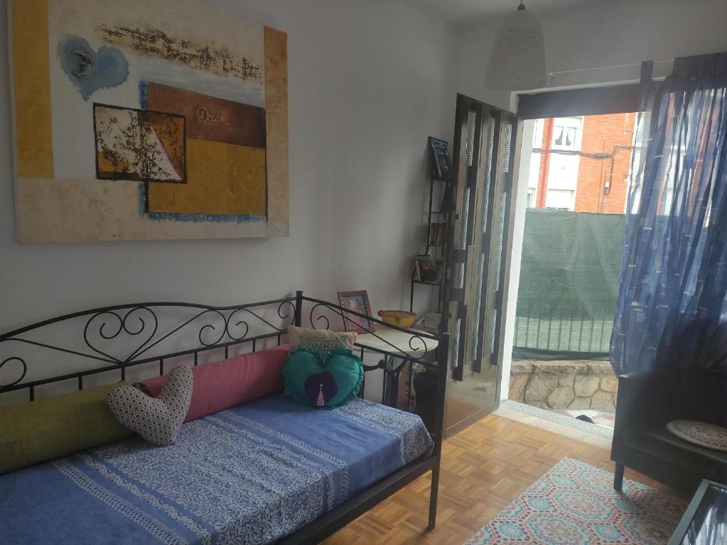 1 dormitorio con cama, ventana y puerta en LA CASINA DE VEGA en Gijón