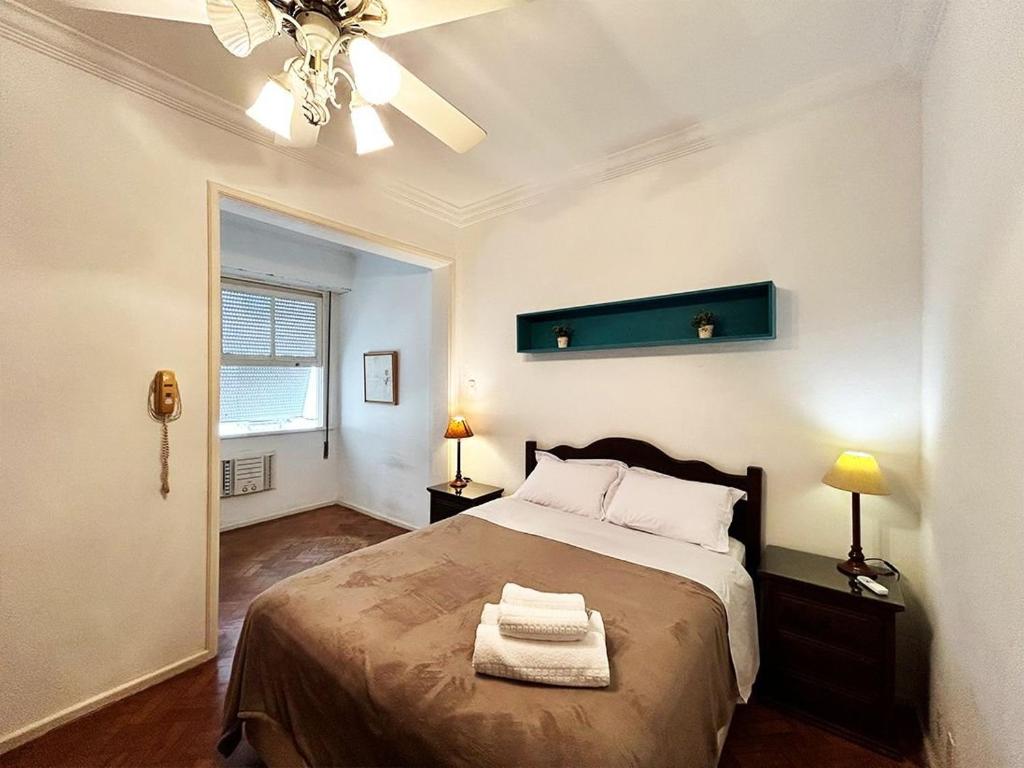 um quarto com uma cama com duas toalhas em BN13 - Apto Espaçoso a 4 min da praia Copacabana no Rio de Janeiro