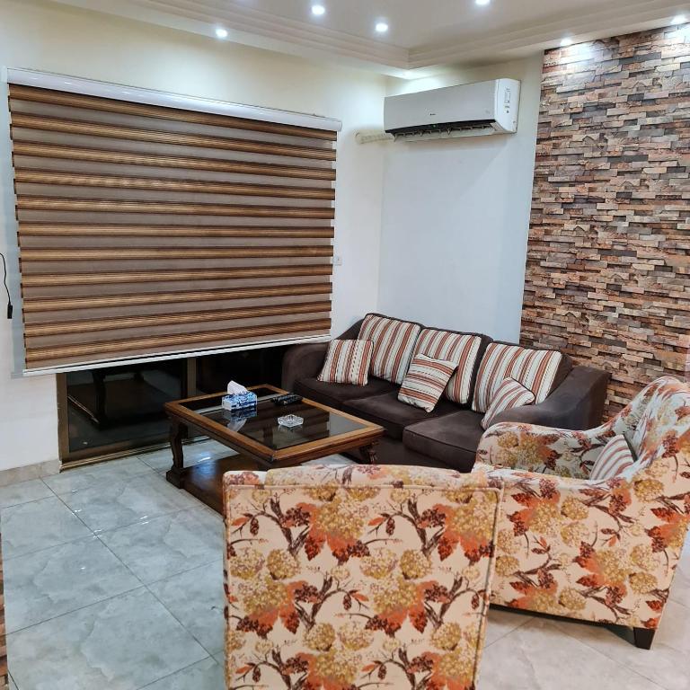 uma sala de estar com um sofá e uma lareira em 2 bedrooms apartment no 18 em Amã