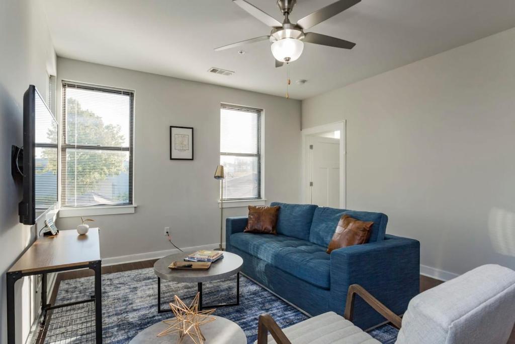 a living room with a blue couch and a table at TWO CozySuites Stylish Music Row Condos w parking in Nashville