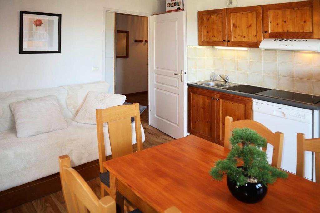 eine Küche und ein Wohnzimmer mit einem Tisch und einem Sofa in der Unterkunft LES CHALETS DE BOIS MEAN - 2 Pièces pour 6 Personnes 024 in Les Orres