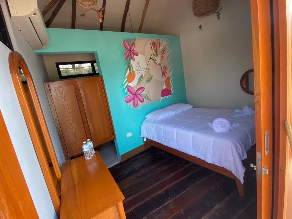 una piccola camera con letto e tavolo di Bahía uvas Bungalos a Banco Playa