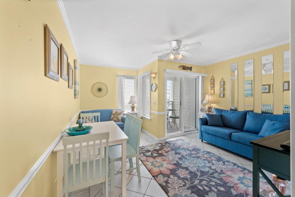 uma sala de estar com um sofá azul e uma mesa em A Place At The Beach WH 308 - Oceanfront - Windy Hill Section em Myrtle Beach