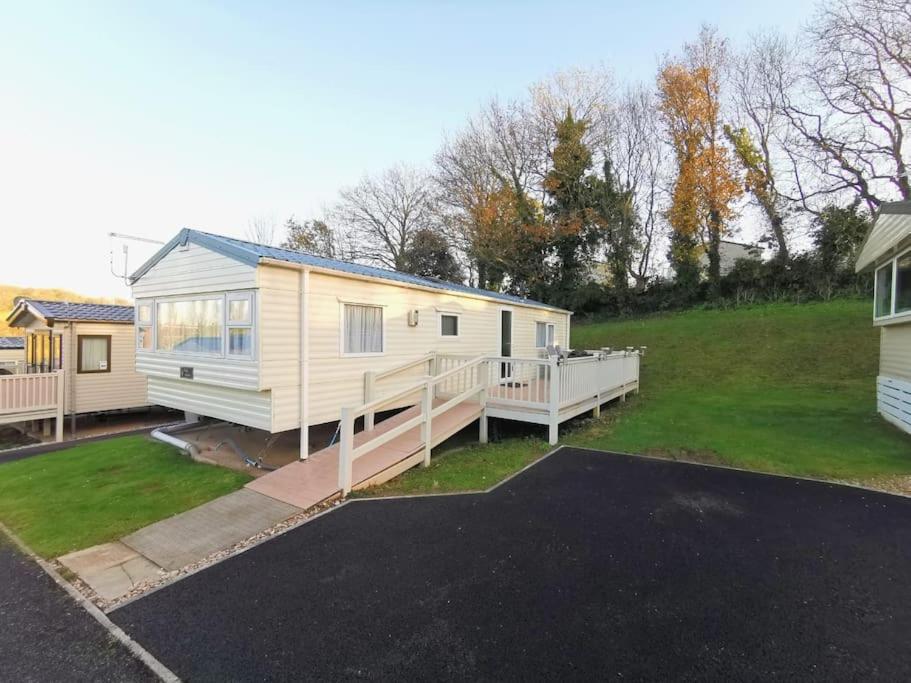 ein weißes Haus mit einer Veranda und einem Hof in der Unterkunft Charming Static Caravan in Dawlish Warren