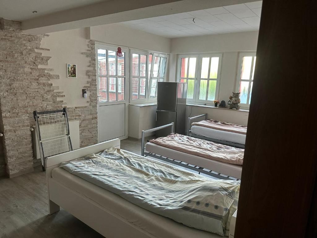 dwa łóżka w pokoju z oknami w obiekcie Hotel Bender w mieście Eschweiler