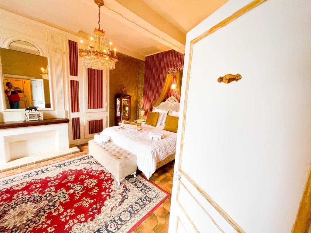 een slaapkamer met een bed en een kroonluchter bij Chateau Bourgeoisie *** in Laimont