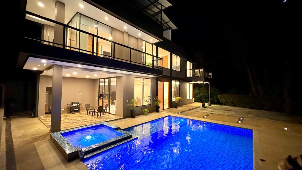 a swimming pool in front of a house at night at Magnifica habitacion Ecohotel !!! in Llanitos