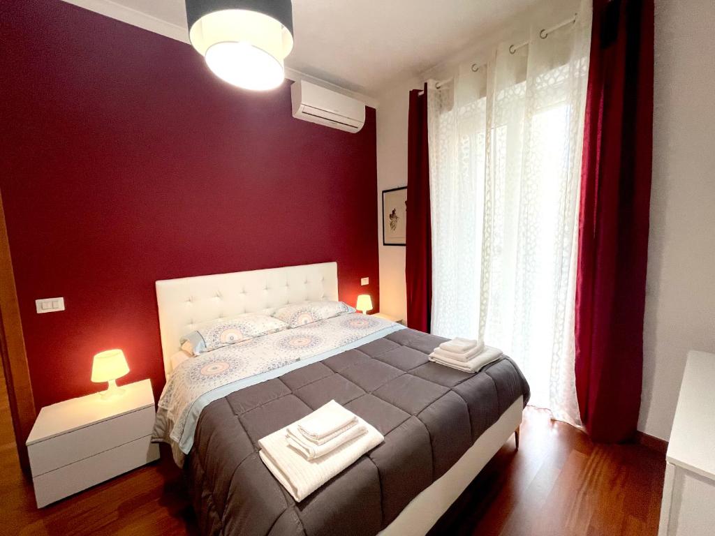 a bedroom with a large bed with red walls at Lucens Domus Appartamento Roma quartiere Trieste - vicino Metro b1 - in Rome