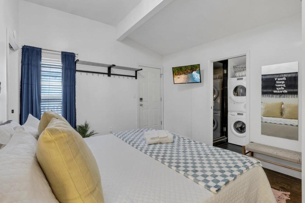 a bedroom with a white bed and a washer and dryer at The Village Cottage in Columbus