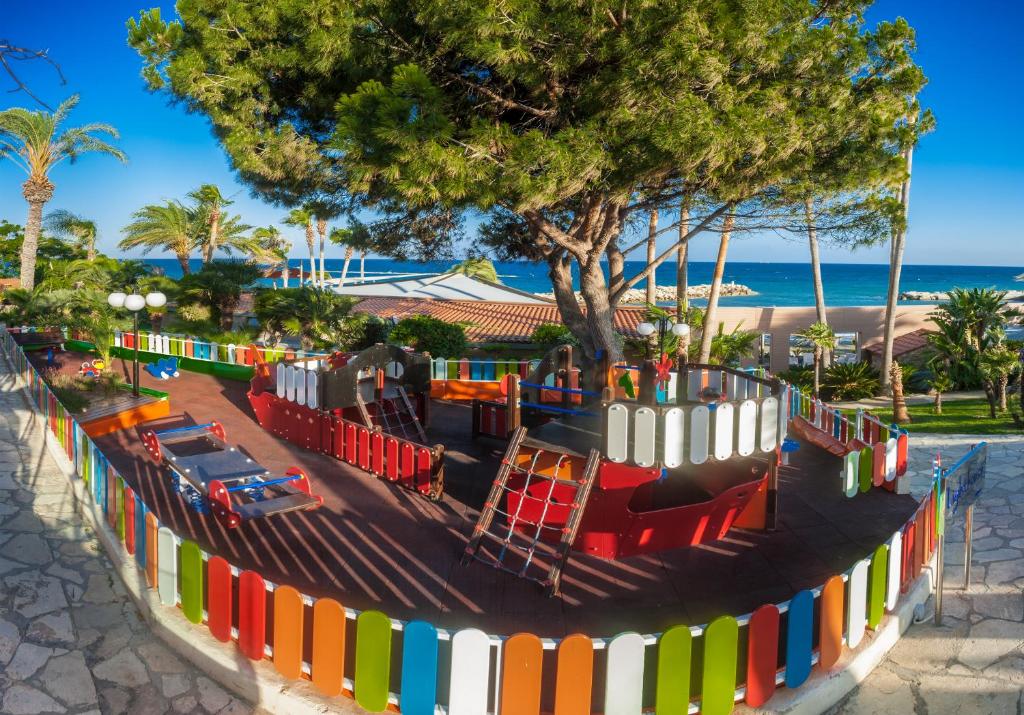 a playground at the beach with a colorful fence at Amathus Beach Hotel Limassol in Limassol