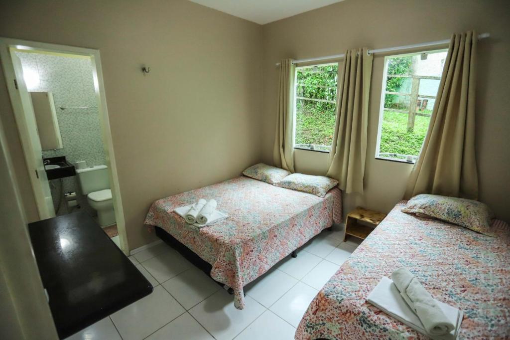 a hotel room with two beds and a window at Sítio Via Láctea - Guaramiranga in Guaramiranga