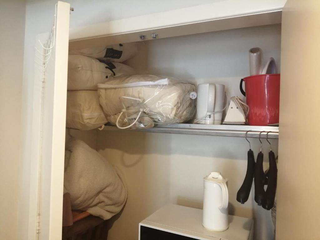 a kitchen pantry with a shelf with items on it at 25 Glenfell Place - One Bedroom Studio in Auckland