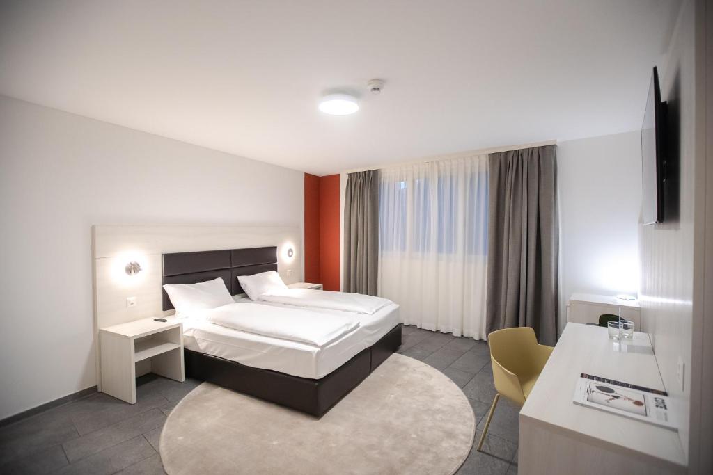 ロカルノにあるMiralago Locarno Easy Roomsのベッドとデスクが備わるホテルルームです。