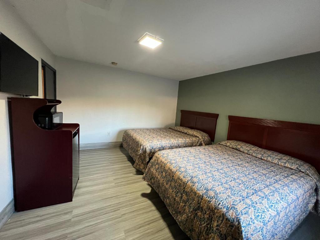 Habitación de hotel con 2 camas y TV de pantalla plana. en Comfort stay inn, en Quincy