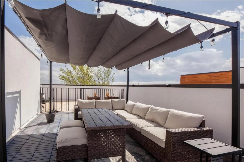 Stylish Luxury + Rooftop Terrace +Downtown Views في دالاس: فناء مع أريكة وطاولة على شرفة