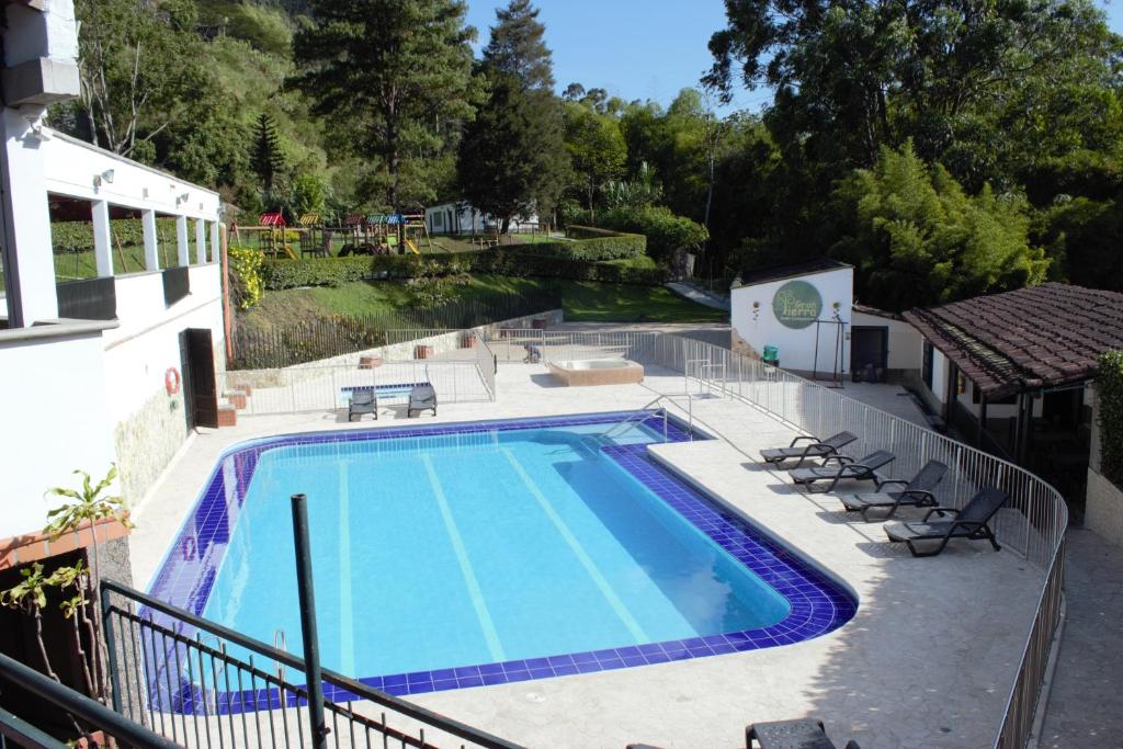 una piscina con sillas y una casa en GH Gran Tierra - Sabaneta, en Sabaneta