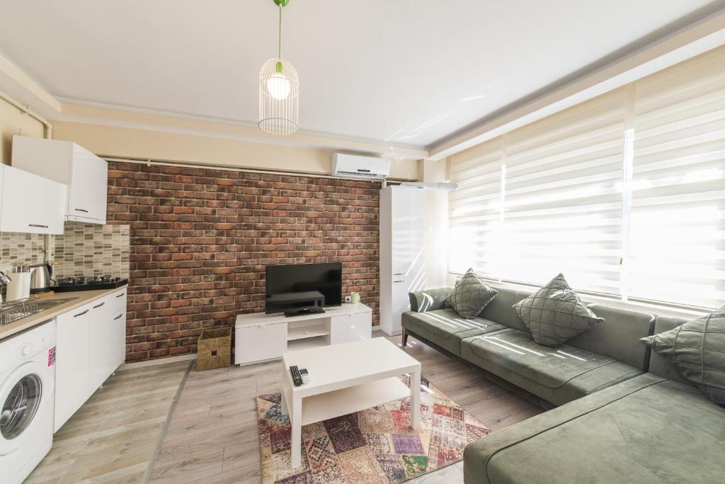 a living room with a couch and a brick wall at White Rose Apart in Istanbul