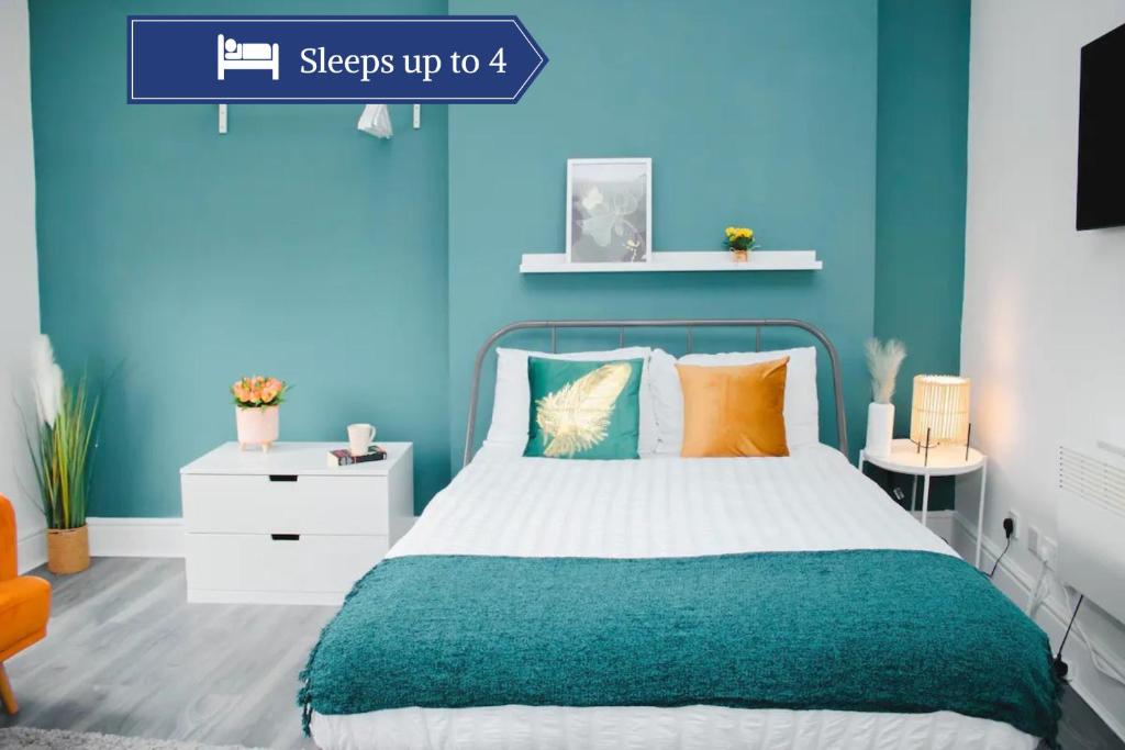 a bedroom with a bed with blue walls at Vibrant Studio Close to Anfield Stadium in Liverpool