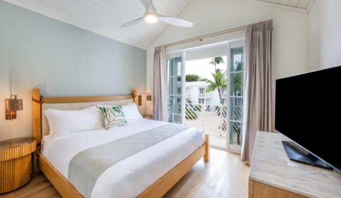 um quarto com uma cama e uma televisão de ecrã plano em Islander Bayside Villas & Boatslips em Islamorada