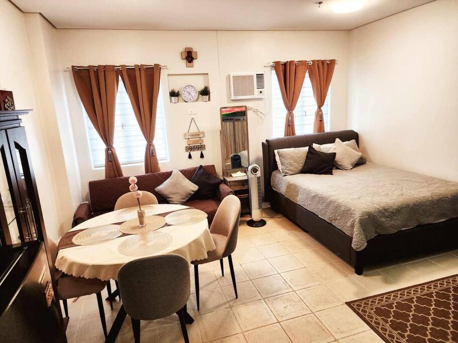 ein Wohnzimmer mit einem Sofa, einem Tisch und einem Bett in der Unterkunft Casa De Castillo in Marilao