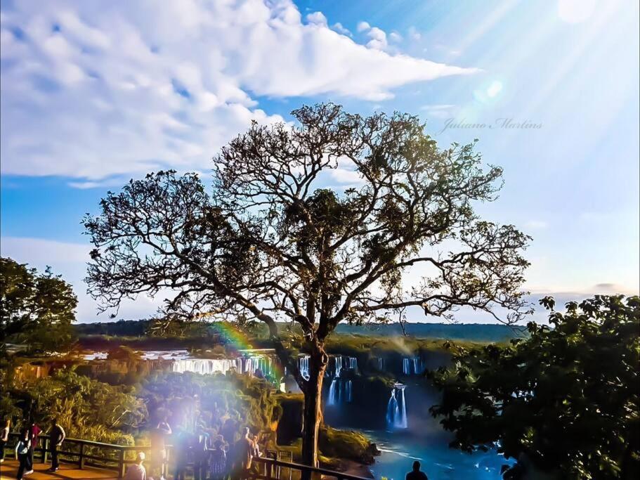 a tree in front of a river with a rainbow at Sobrado aconchegante e espaçoso, ótima opção! in Foz do Iguaçu