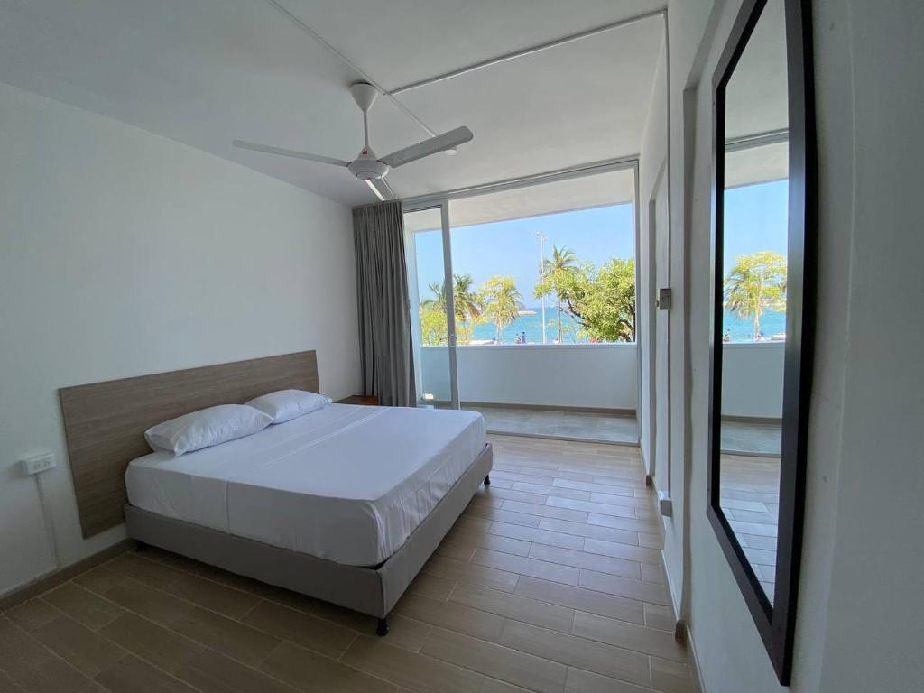 Un dormitorio con una cama y un espejo grande. en Panamerican Hostel, en Santa Marta