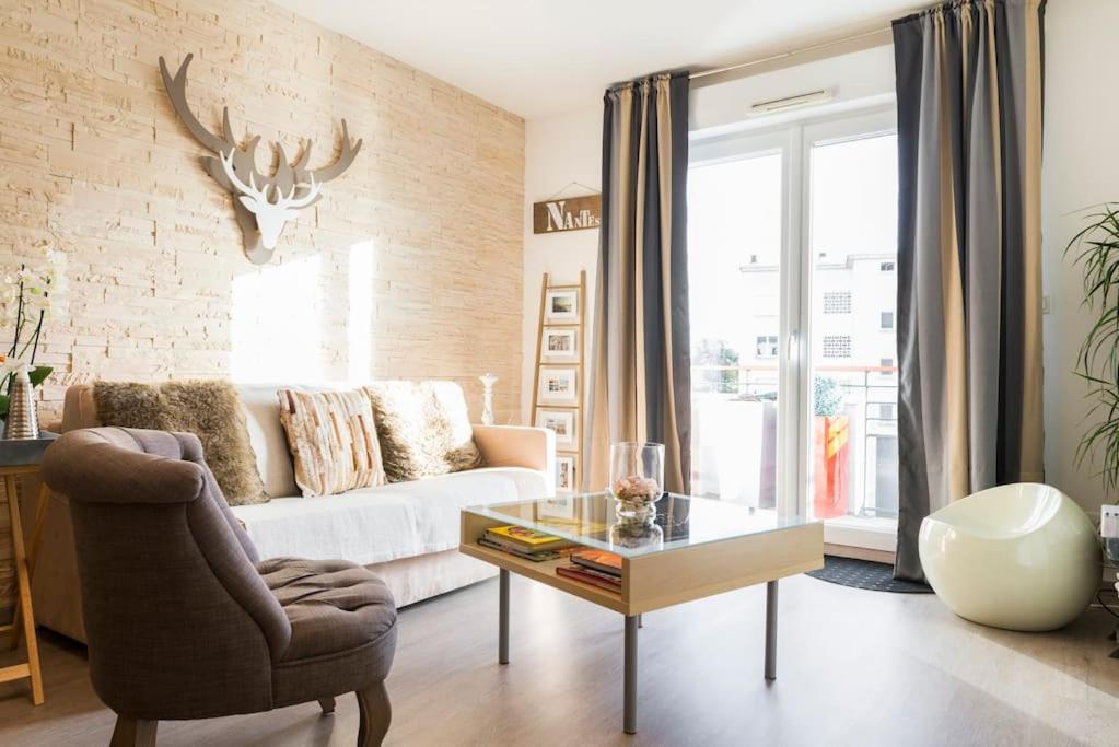 a living room with a couch and a glass table at Petit Erdre - 2 chambres- gd appt ensoleillé- accès PMR in Nantes