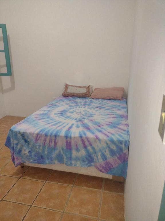 Una cama pequeña con un edredón colorido en una habitación en Cada De Hospedagem Vida No Paraíso en Angra dos Reis