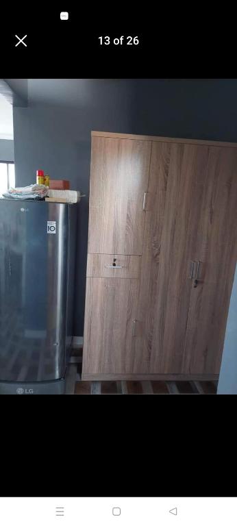 een houten kast in een keuken naast een koelkast bij Yang guest house/private room in Dauis