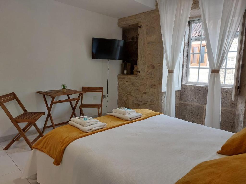 a bedroom with a bed with two towels on it at A Taberna de Gundián in Vedra