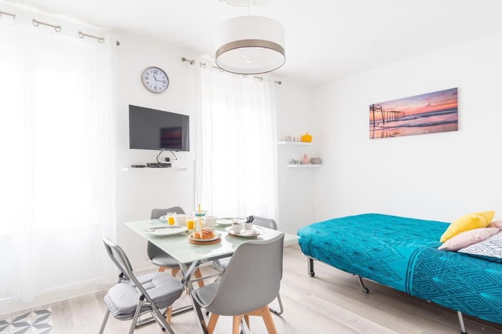 une chambre avec un lit, une table et des chaises dans l'établissement Le Petit Cocon - 150m de la Plage - 3 pers, à Étretat