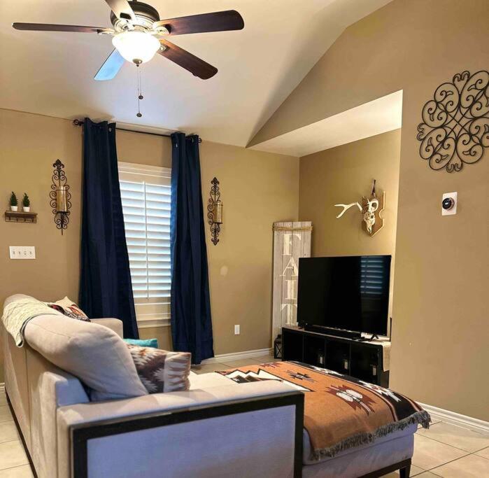 a living room with a couch and a flat screen tv at Western Style - 2 bed/1 bath (RATED 10 STARS) in Eagle Pass
