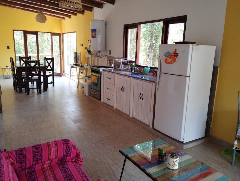 eine Küche mit einem weißen Kühlschrank und einem Tisch in der Unterkunft Luna Jatun in Purmamarca