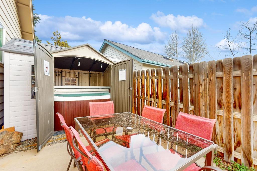 a patio with a table and chairs and a fence at Poree Domaine Bend in Bend