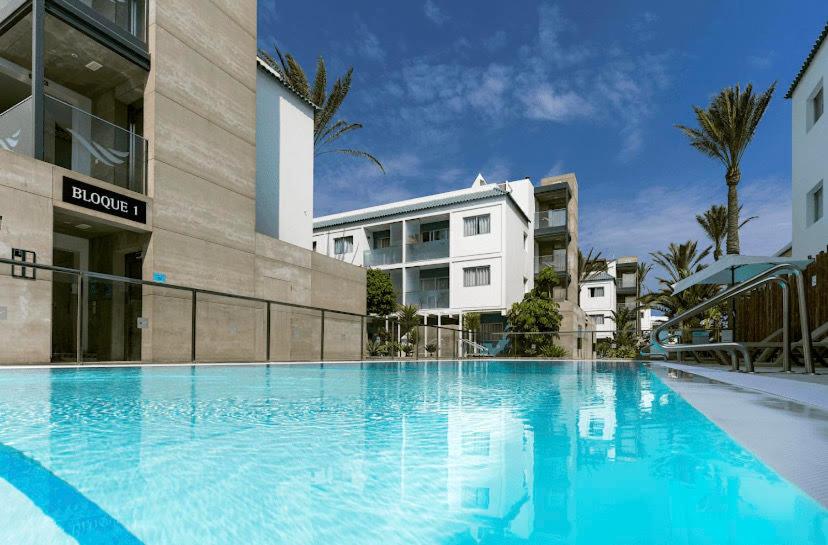 uma grande piscina azul em frente a um edifício em Casa Sol Bristol Sunset Beach em Corralejo