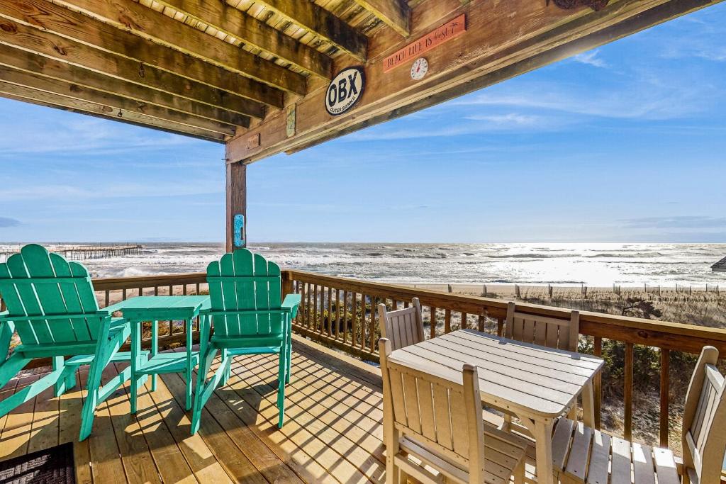 a deck with chairs and tables on the beach at Tressa Terrace in Avon