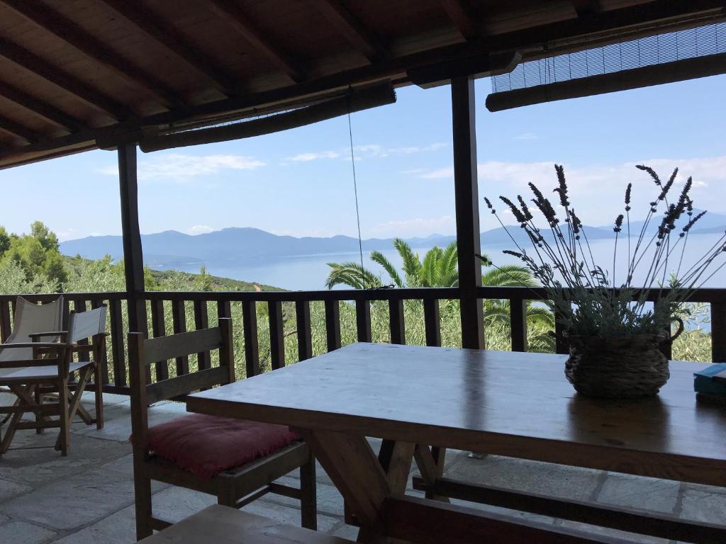 een tafel en stoelen op een patio met uitzicht op de oceaan bij Olive Grove House in Argalasti