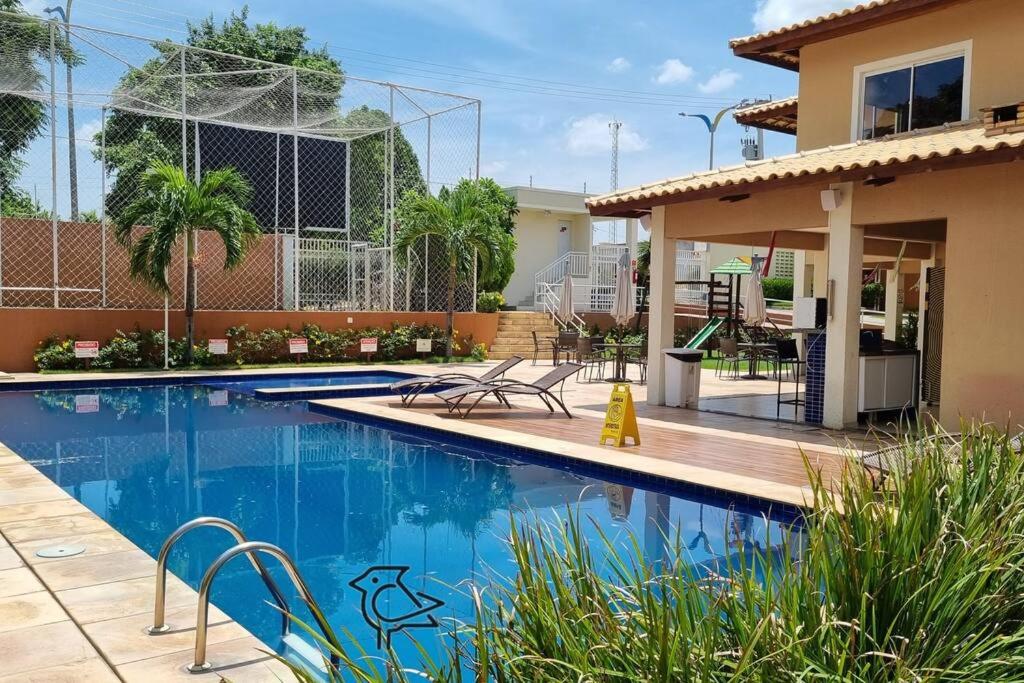 una piscina di fronte a una casa di Cariri Vivenda - Apto completo com 02 quartos climatizados, estacionamento e portaria 24 horas a Juazeiro do Norte