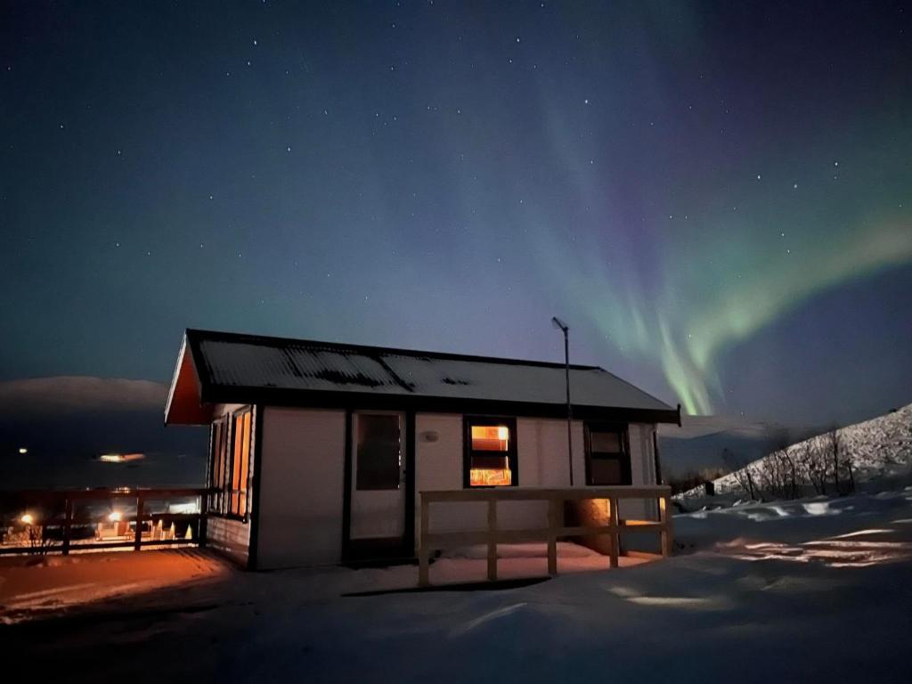 un pequeño edificio con la aurora en el cielo en Bakkaflöt Guesthouse en Varmahlid