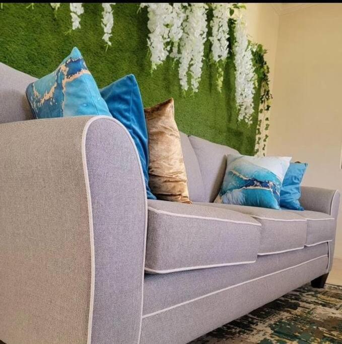 um sofá com almofadas na sala de estar em The Luxe Room & Suite em Saint Michael