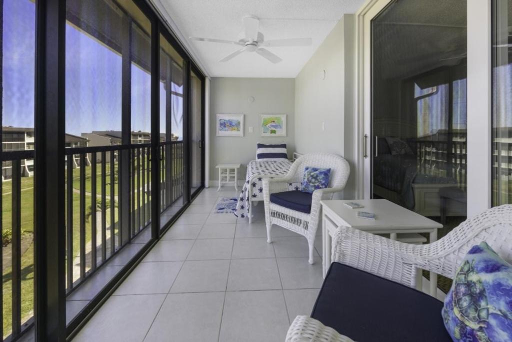 a balcony with wicker chairs and a table at Loggerhead 314 condo in Sanibel