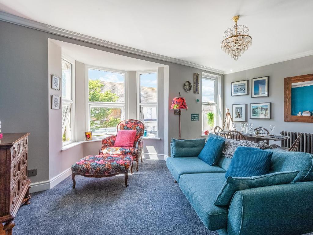 sala de estar con sofá azul y silla en Hereward House en Margate