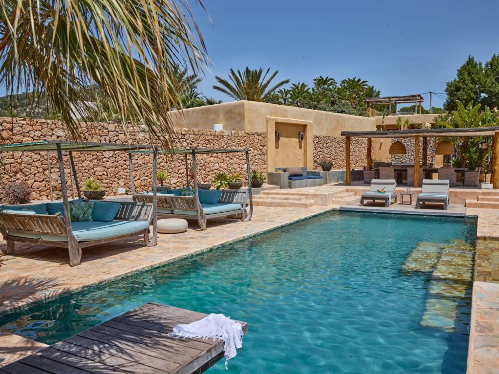 カラ・ヴァデラにあるBeautiful holiday home with private poolのスイミングプール(椅子付)と家