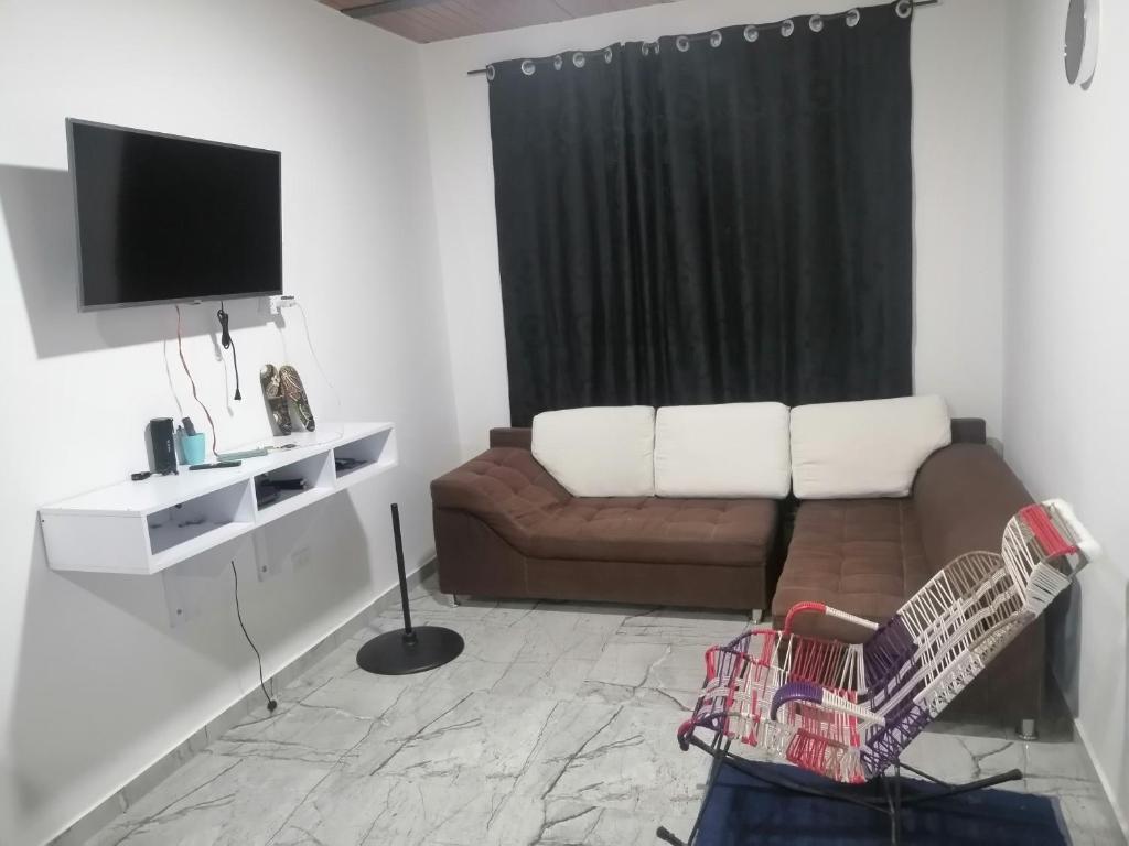 sala de estar con sofá y TV en Las kaicas, en Acacías