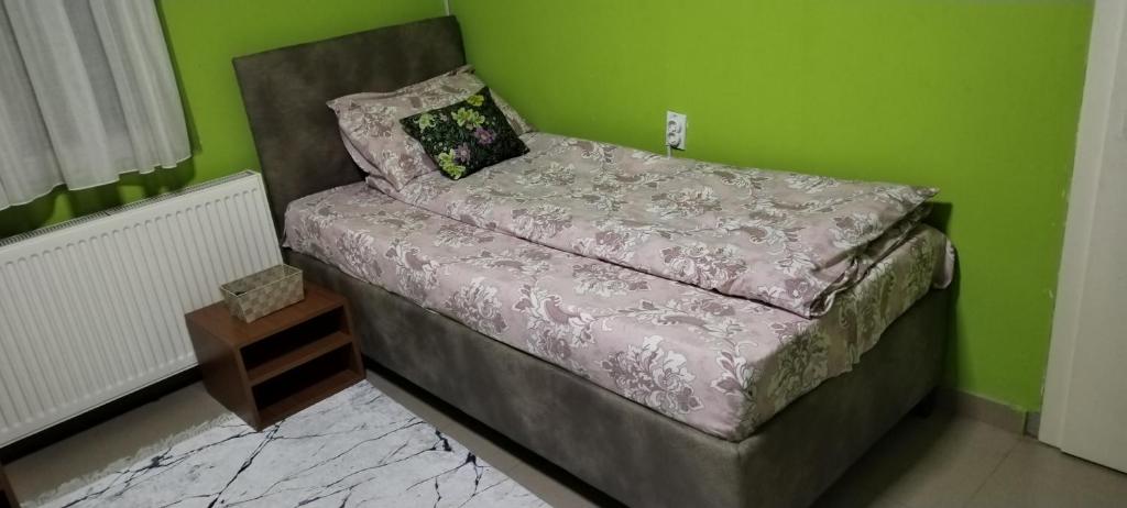 een bed in een kamer met een groene muur bij Eko Vlasina in Vlasotince
